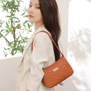Elegant brown quilted PU leather underarm bag for women shown with model in natural light