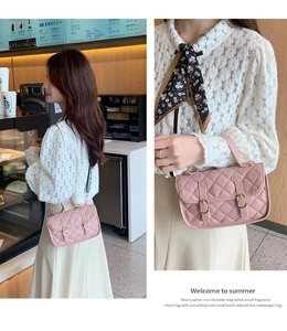 Detailed view of pink quilted leather crossbody bag with dual buckles and chain strap