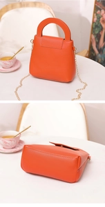Vue détaillée du mini sac Boston orange avec texture en similicuir et chaîne dorée