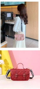 Detail of pink and red quilted crossbody bags with decorative gold buckles and wide straps