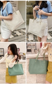 Detail of large tote bag with geometric pattern and slim shoulder straps in outdoor setting