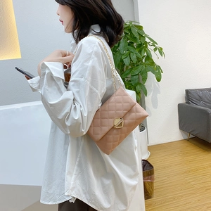 Elegant beige quilted crossbody bag with gold geometric lock and fine chain strap