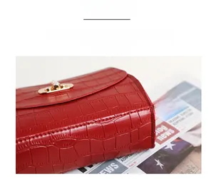 Detailed macro view of the structured red crocodile pattern leather bag and gold lock