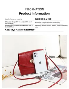Detail of red croc-embossed crossbody bag with pearl clasp next to a phone for scale