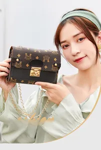 Detail of classic patterned mini square bag with golden chain strap and metal lock
