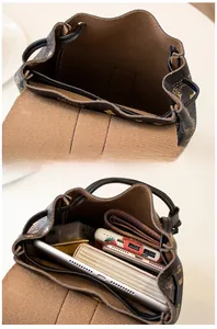 Internal storage detail showing vintage bucket backpack fitting an iPad and essentials
