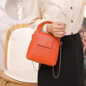 Sac seau Boston minimaliste en cuir orange avec bandoulière chaîne dorée pour femme