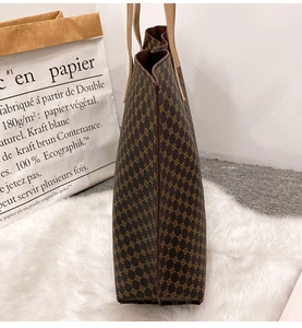 Side view of large retro tote bag with geometric pattern and brown leather handle