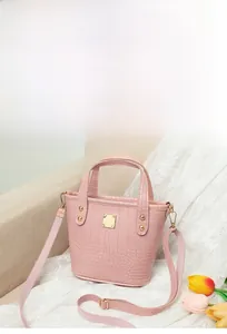Detalle de bolso bucket rosa con grabado de cocodrilo y herrajes dorados elegantes