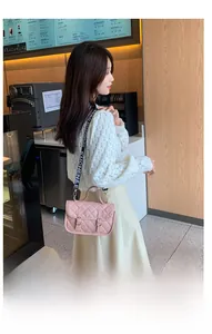 Detail of light pink quilted crossbody bag with stylish patterned wide shoulder strap