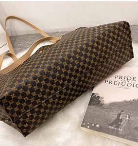 Detail view of brown vintage tote bag with geometric print on white plush rug