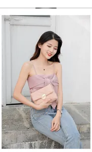Detailed view of quilted peach crossbody bag featuring a golden mouse-shaped metal lock