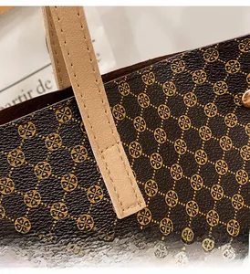 Macro detail of tote bag showing reinforced stitching on the brown handle and floral print