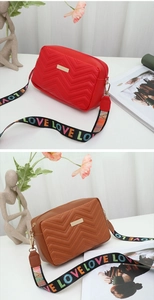 Detail of wave quilted crossbody camera bags with colorful LOVE patterned straps