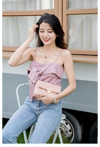 Close-up of pink quilted crossbody bag with golden mouse-shaped buckle and chain strap