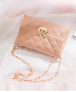 Detail of pink quilted shoulder bag with golden chain and unique mouse-shaped lock