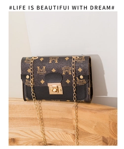 Detail of vintage brown monogram bag with golden twist lock and chain strap