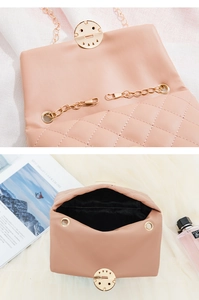 Detail of light pink quilted bag featuring a unique gold smiley face metal lock buckle