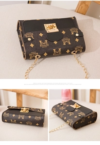 Close-up of vintage monogram brown leather crossbody bag with gold chain and square lock