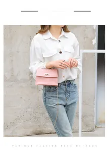 Detailansicht einer rosa Mini-Tasche mit Kroko-Prägung, Perlengriff und goldener Kette