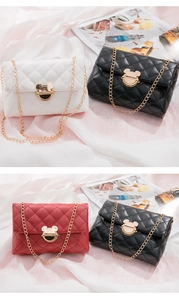Close-up of quilted chain bags in white, black and red with gold Mickey head clasps