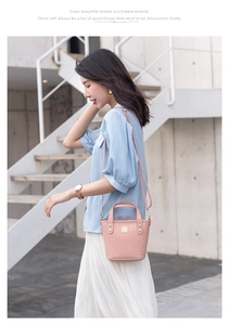 Bolso saco rosa con relieve de cocodrilo modelado en una escalera exterior minimalista