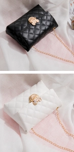Detail of quilted leather bags in black and white with golden mouse-shaped metal buckles