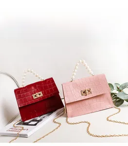Detailansicht der roten und rosa Krokostruktur-Minitaschen mit Perlengriffen und Goldketten