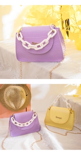 Details kleiner Krokodilmuster-Taschen mit bunten Kunststoffketten und Metallriemen