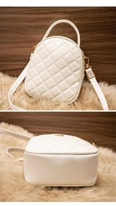 Close-up of white quilted mini bag with gold logo and textured faux leather finish
