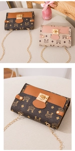 Close-up of retro printed chain bag with metal twist lock and geometric logo patterns
