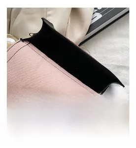 Macro view of the large capacity interior of a pink leather crossbody bag with gold clasp