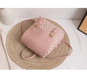 Makroansicht der rosa gemusterten Tasche mit goldenen Schnallen auf einer Matte
