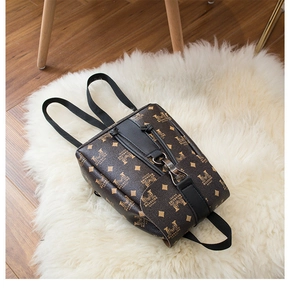 Detail of vintage brown mini backpack with monogram pattern and black drawstring closure
