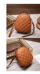 Close-up of brown quilted PU leather mini bag with gold floral ornament and marble backdrop