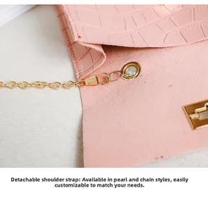 Detail der rosa Mini-Tasche mit Kroko-Prägung, abnehmbarer Goldkette und Perlenakzenten