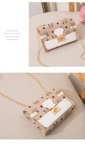 Detail of a beige monogram crossbody bag with gold chain strap and metal lock closure