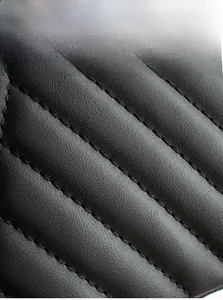Détail macro du motif matelassé élégant sur le sac à bandoulière en cuir noir
