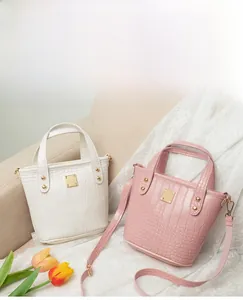 Detalle de los bolsos bombonera rosa y blanco con patrón de cocodrilo y placas de metal