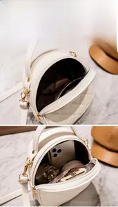Detail view of a white quilted round bag showing interior space for phone and makeup