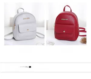 Detail of mini faux leather backpacks in grey and red with metallic brand logo