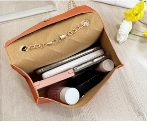 Interior view of an orange crossbody bag showing ample storage space for cosmetics