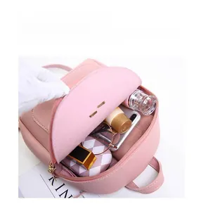 Pink minimalist backpack interior showing storage capacity for sunglasses and cosmetics