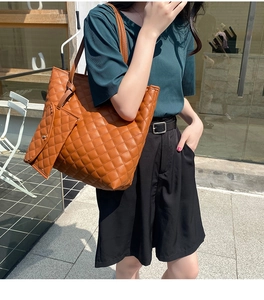 Brown quilted tote bag set with matching pouch shown on a model in urban setting