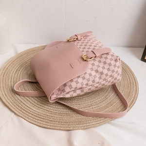 Kleiner bedruckter Canvas-Rucksack in Rosa mit goldenen Schnallen auf einer Matte