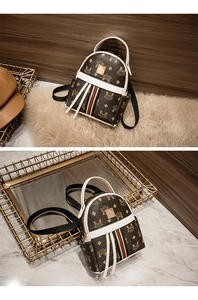 Close-up of mini leather backpack featuring bear monogram print and striped ribbon detail