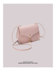 Detail of dusty rose mini bag featuring wavy flap, gold hardware and pearl charm