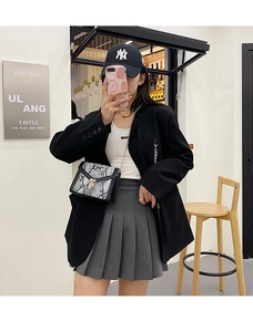 Fashionable snake print chain crossbody bag styled with a black blazer and grey skirt