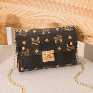 Vintage style brown monogram chain crossbody bag with gold hardware on a wooden chair