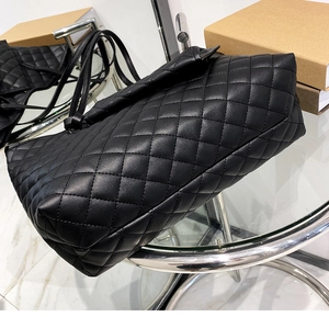 Detail view of quilted leather tote bag with classic diamond stitching and glossy finish